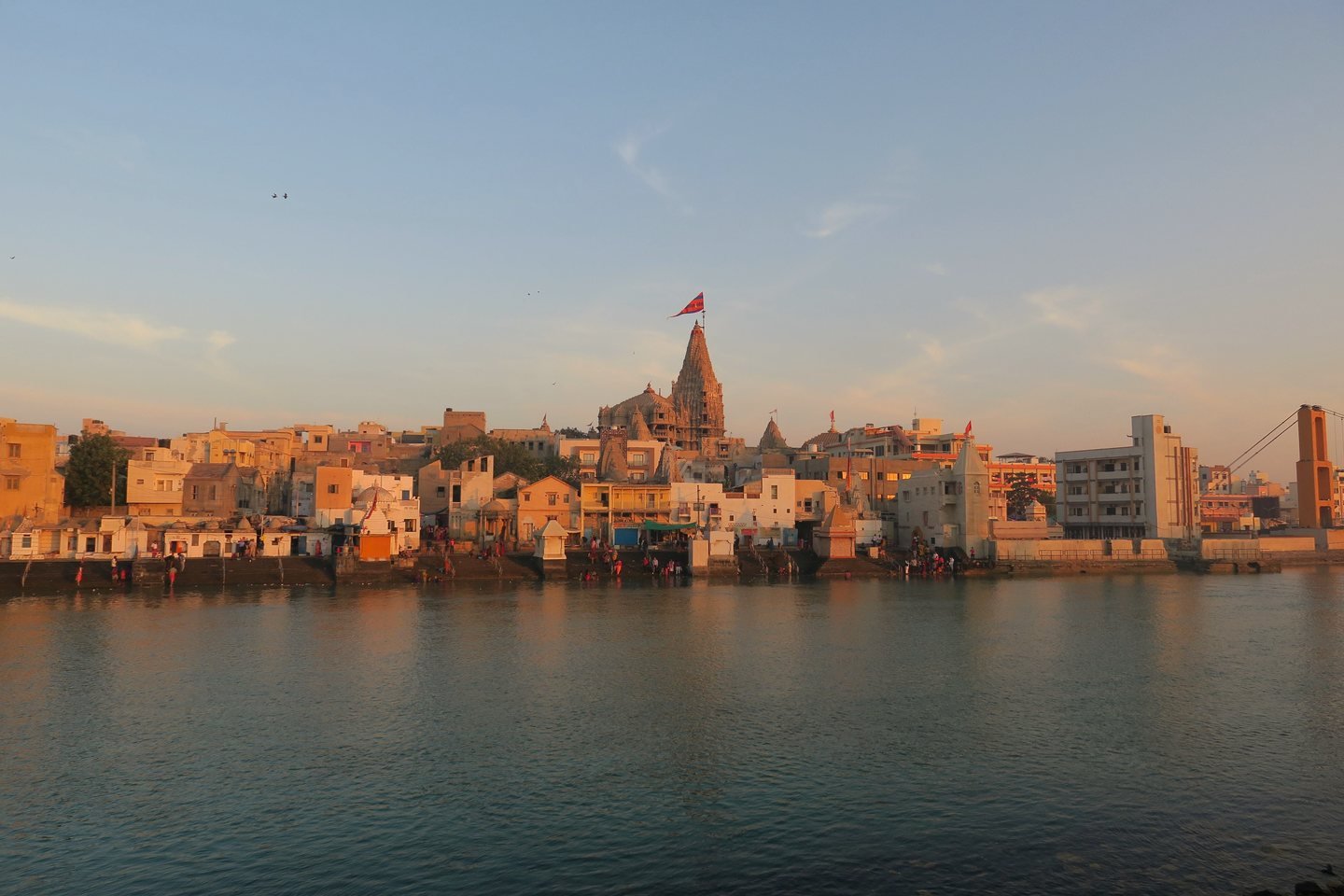Dwarkadhish Temple and the old town of Dwarka across the Gomti river at sunset